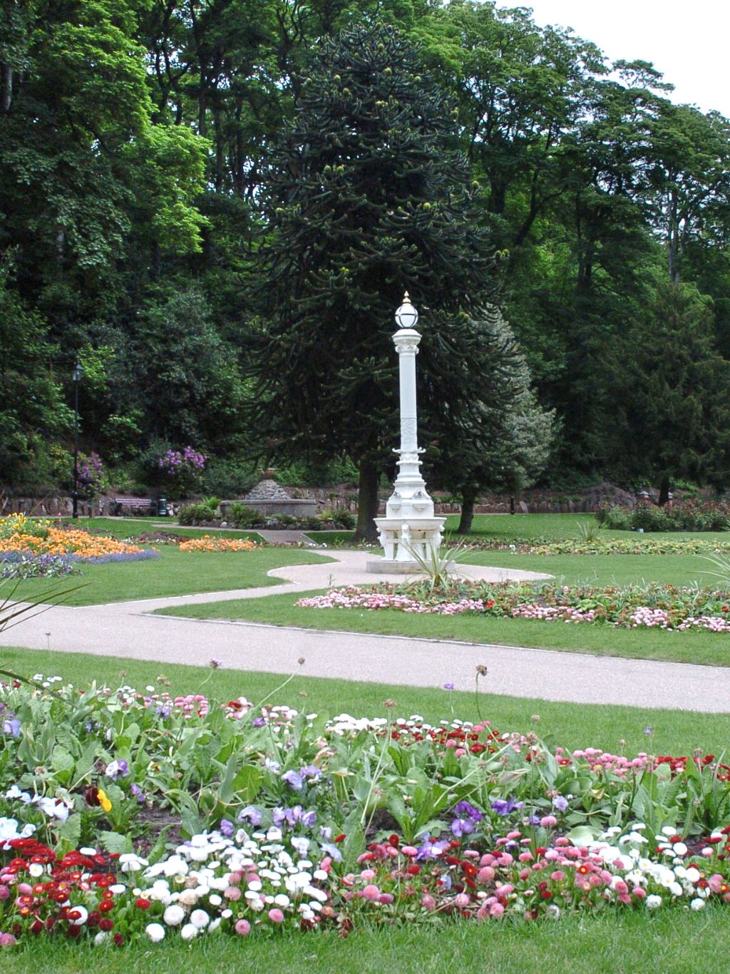 Flowers in the park with ladies on a bench