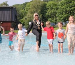 Mayor of Congleton splashing in the paddling pool with children.