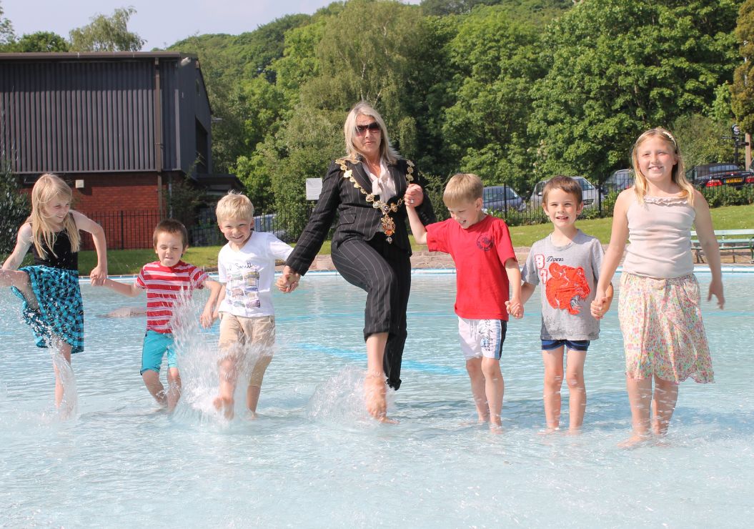 Mayor of Congleton splashing in the paddling pool with children.